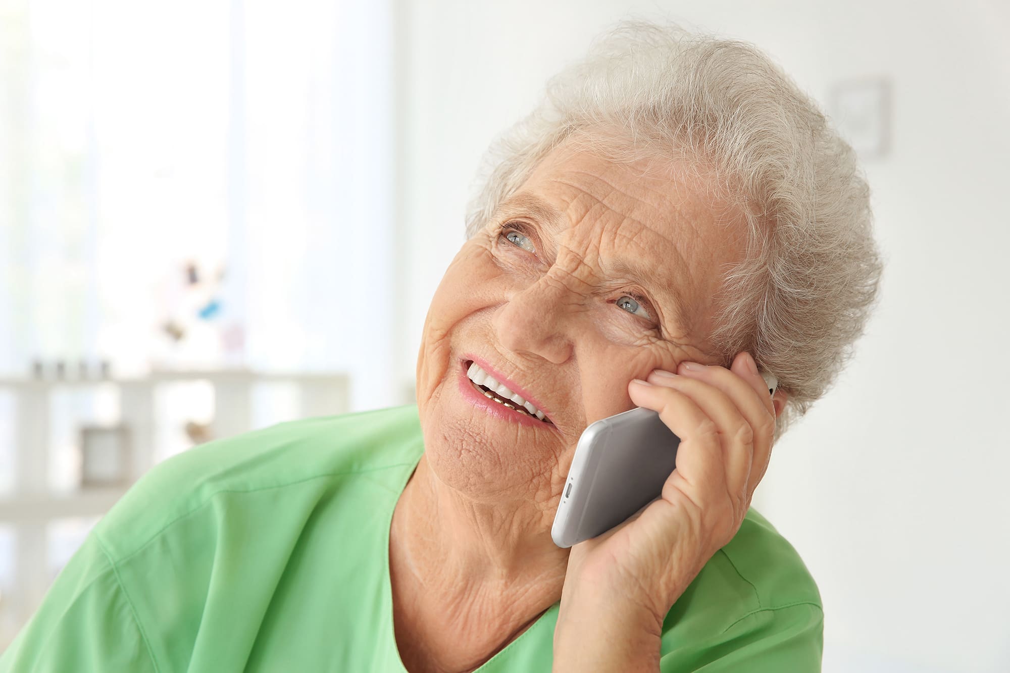 Senior woman on phone and smiling.